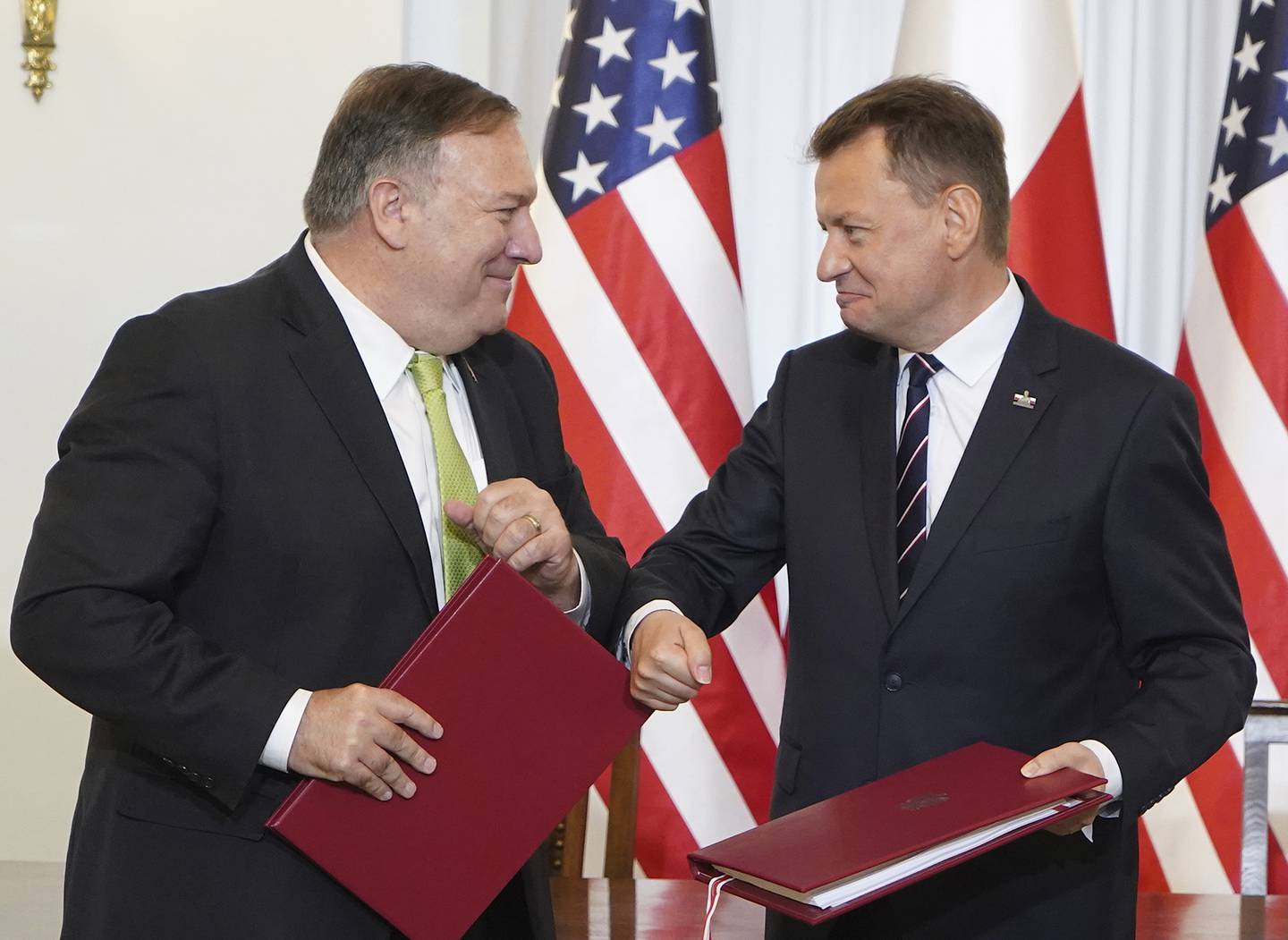U.S. Secretary of State Mike Pompeo, left, and Poland's Minister of Defence Mariusz Blaszczak greet each other after signing the US-Poland Enhanced Defence Cooperation Agreement in the Presidential Palace in Warsaw,  Poland, Saturday Aug. 15, 2020.