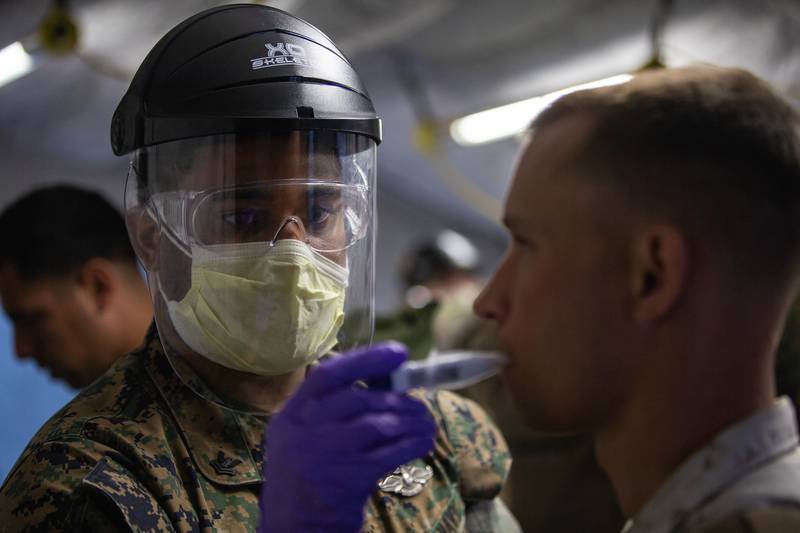 Hospital Corpsman 2nd Class James Mckenzie takes the temperature of a Marine on Marine Corps Air Station Cherry Point, N.C., on March 31, 2020.
