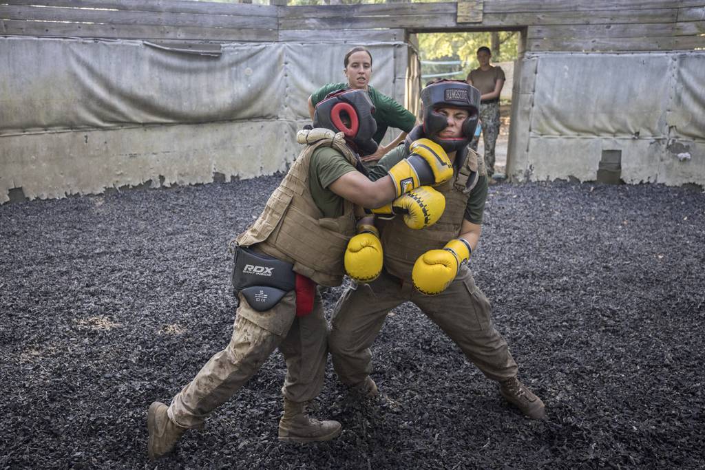 U.S. Marine Corps martial arts instructor Sgt. Micah Shull, center, trains two female recruits during a hand-to-hand combat drill during a portion of training known as the Crucible at the Marine Corps Recruit Depot, Thursday, June 29, 2023, in Parris Island, S.C.