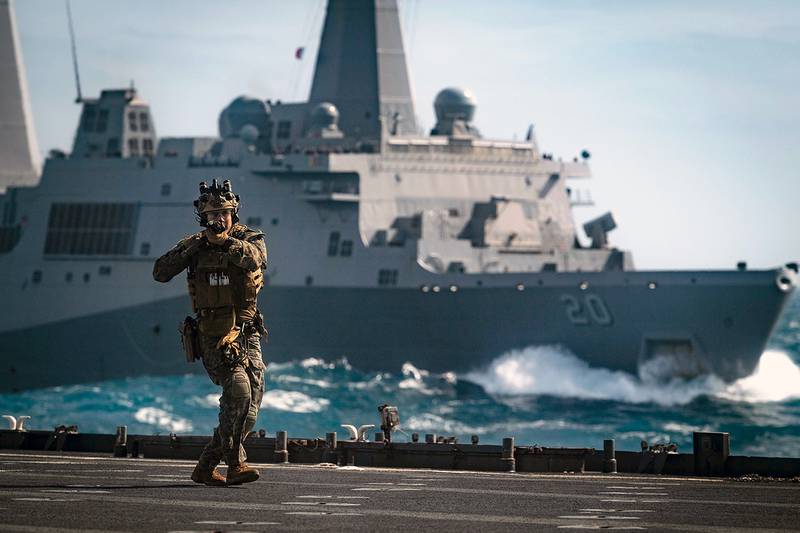 A Force Reconnaissance Marine clears the flight deck of the amphibious dock landing ship USS Ashland (LSD 48) on July 7, 2019, during a visit, board, search and seizure training exercise with the amphibious transport dock ship USS Green Bay (LPD 20) in the Coral Sea.