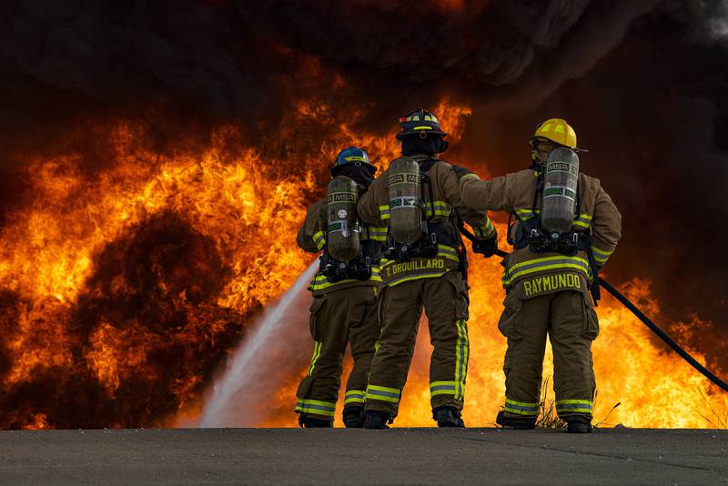 Airman Andrew Burr, 7th Civil Engineer Squadron firefighter, Senior Airman Thomas Drouillard, 445th CES firefighter, and Justin Raymundo, 7th CES firefighter, extinguish a fire on an aircraft fire trainer at Dyess Air Force Base, Texas, Sept. 15, 2020.