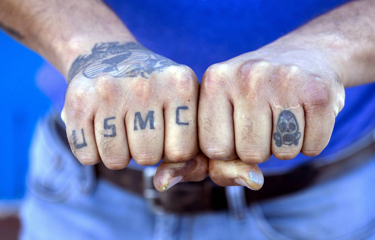 Veteran Cesar Lopez displays his USMC tattoos outside his home in Las Vegas