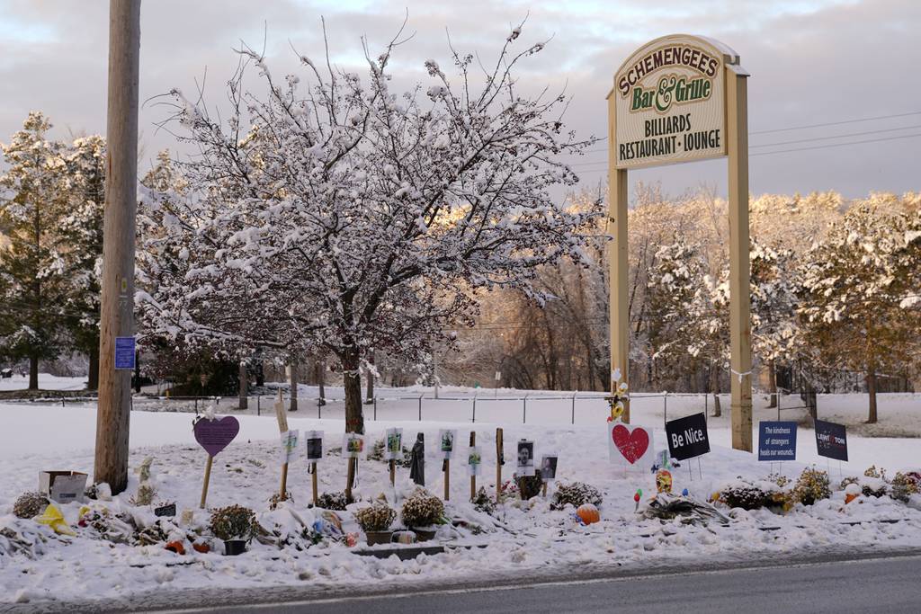 Snow accumulates outside a restaurant at a makeshift memorial for the victims of last month's mass shooting in Lewiston, Maine, Tuesday, Dec. 5, 2023.