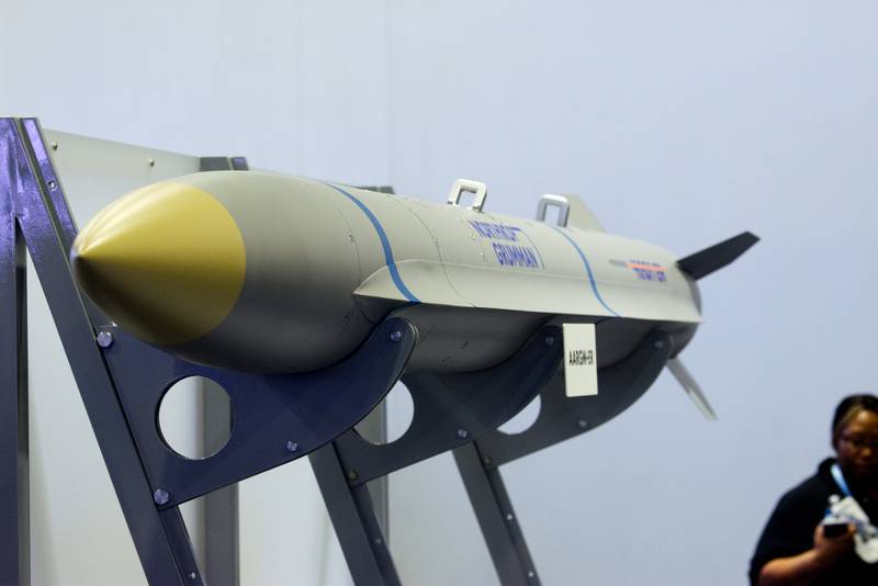 An attendee of the Sea-Air-Space conference walks behind a Northrop Grumman model of the Advanced Anti-Radiation Guided Missile Extended Range weapon on April 5, 2023. (Colin Demarest/Staff)