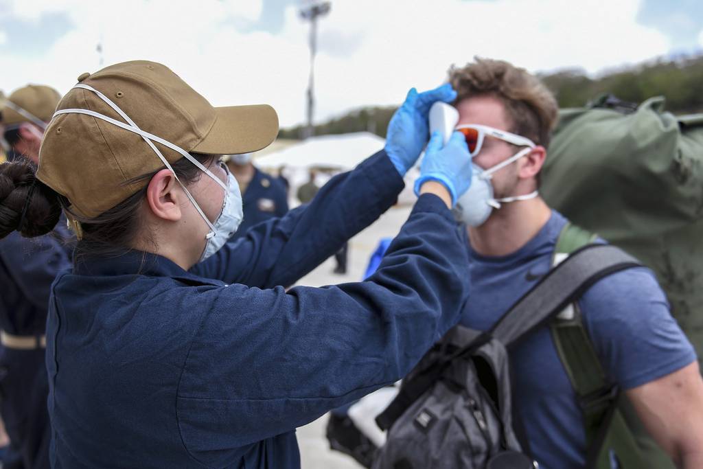 Sailors assigned to the aircraft carrier Theodore Roosevelt (CVN 71), who have tested negative twice for COVID-19 and are asymptomatic, arrive pierside and prepare to return to the ship on April 30, 2020, following completion of their off-ship quarantine at Naval Base Guam