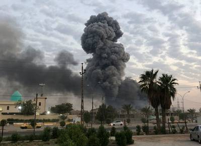 In this Monday, Aug. 12, 2019, photo, plumes of smoke rise after an explosion at a military base southwest of Baghdad, Iraq.