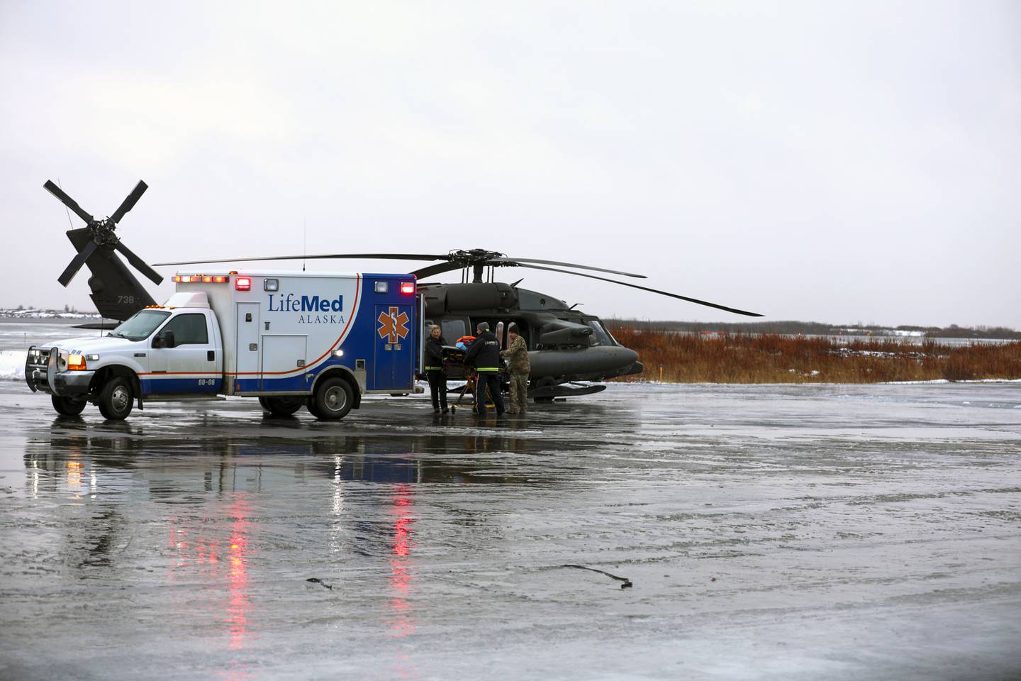 This photo provided by the Alaska National Guard shows, from the left, Holly Demmert and Clifton Dalton, both flight paramedics with LifeMed, and Chief Warrant Officer 3 Bryan Kruse, Bethel Army Aviation Operating Facility commander, move a critically ill patient from an AKARNG UH-60L Black Hawk helicopter to an ambulance during a medical evacuation from Napaskiak to Bethel, Wednesday, Nov. 15, 2023 in Bethel, Alaska.