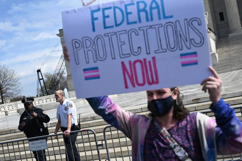 An activist holds a sign calling for federal protections of transgender rights, in front of the U.S. Supreme Court in Washington, D.C., on April 1, 2023.