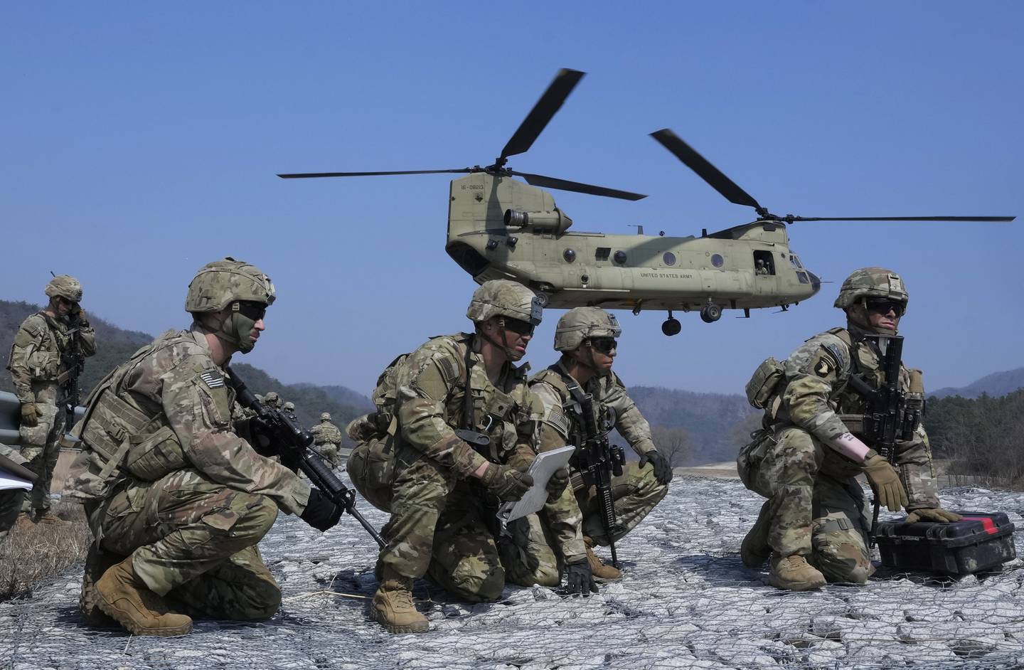 U.S. Army soldiers wait to board their CH-47 Chinook helicopter during a joint military drill between South Korea and the United States at Rodriguez Live Fire Complex in Pocheon, South Korea, Sunday, March 19, 2023.