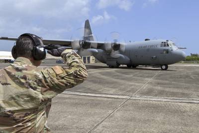 Staff Sgt. Oscar Corchado, an aircraft mechanic with the 156th Contingency Response Group, salutes a C-130 Hercules aircraft from the 123rd Airlift Wing, Kentucky Air National Guard, departing the flight line at Muñiz Air National Guard Base, Puerto Rico, June 18, 2021. (Master Sgt. Caycee Watson/Air National Guard)