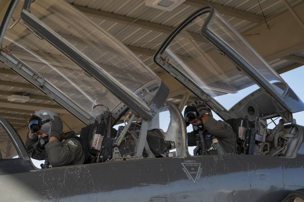1st Lt. Julian Flores (left), 47th Student Squadron student pilot, and 1st Lt. Gabriel Martinez (right), 87th Flying Training Squadron instructor pilot, adjust their helmets as they prepare for a T-38 Talon flight at Laughlin Air Force Base, Texas, July 25, 2022. Laughlin trains the most pilots of any training base in the Air Force. (Airman 1st Class Kailee Reynolds/Air Force)