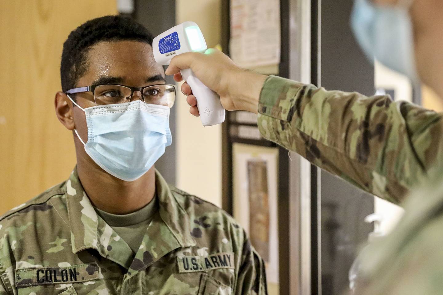 A soldier has his temperature taken during screenings for COVID-19 at Fort Hood, Texas, July 13, 2020.