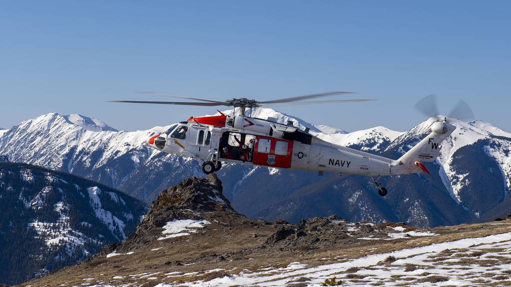 An MH-60S Sea Hawk helicopter from Naval Air Station Whidbey Island prepares to land during an Alpine Search and Rescue training mission in the Olympic Mountains on Feb. 19, 2019.
