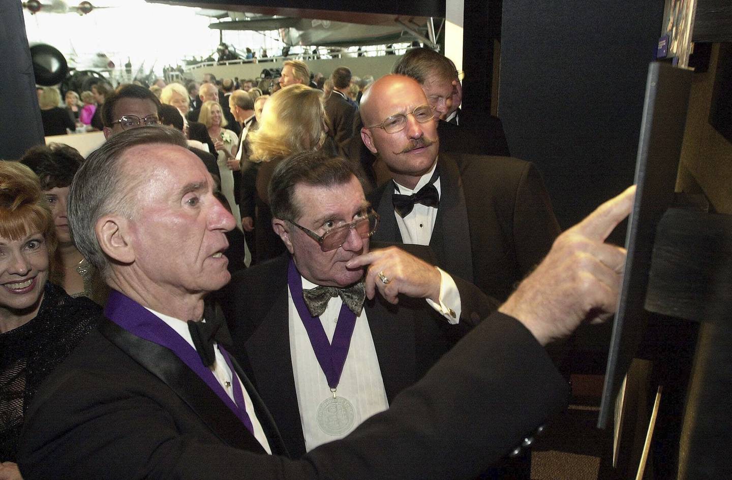 Apollo 7 astronaut Walter Cunningham, left, points to pictures of fellow astronaut the late Charles "Pete" Conrad while speaking with Apollo 10 astronaut Dick Gordon, center, and Andy Conrad, the son of Charles Conrad, at the opening of the Rendezvous in Space exhibit at the Museum of Flight in Seattle, Wash., July 22, 2000.