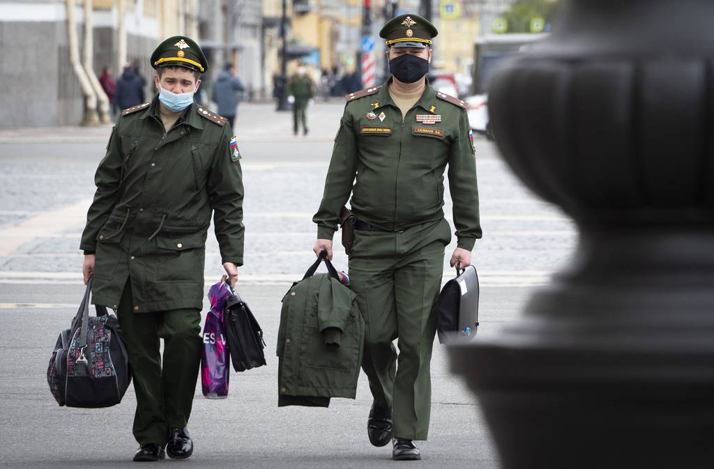 Russian army officers wearing face masks to protect against coronavirus walk in St. Petersburg, Russia, Tuesday, May 19, 2020.