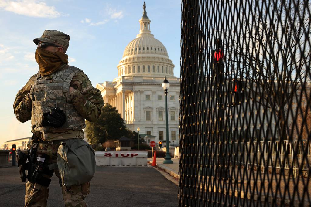 A member of the New York National Guard stands at a gate outside the U.S. Capitol on Jan. 14, 2021, the day after the House of Representatives voted to impeach President Donald Trump for the second time.