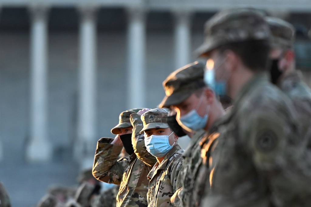 Members of the National Guard stand at attention after arriving on Capitol Hill on Jan. 12, 2021, in Washington.