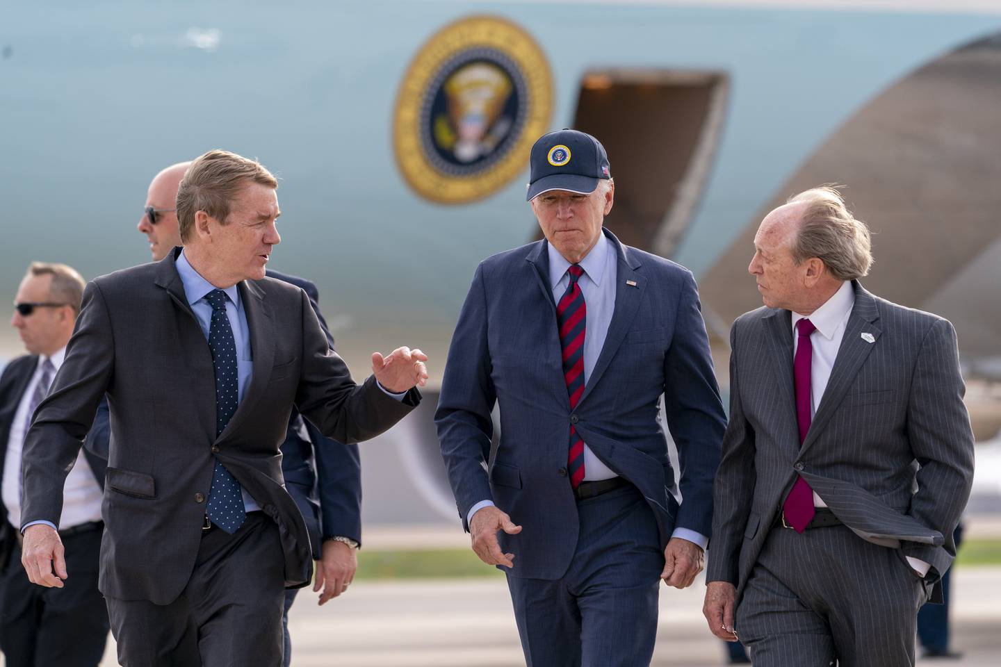 Air Force One is visible as President Joe Biden, center, speaks with by Sen. Michael Bennet, D-Colo., left, and Colorado Springs Mayor John Suthers, right, as he arrives at Peterson Space Force Base in Colorado Springs, Colo., Wednesday, May 31, 2023.