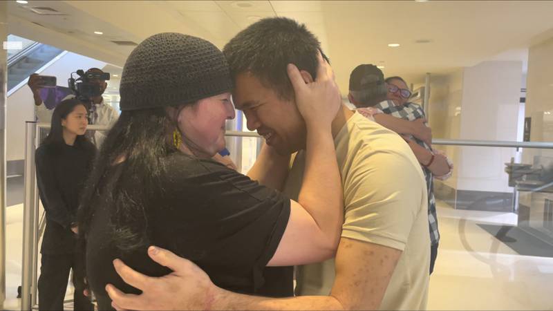 Andy Huynh, left, and Alex Drueke, far right, are seen hugging their loved ones after arriving at Birmingham-Shuttlesworth International Airport in Birmingham, Ala., Saturday, Sept. 24, 2022.