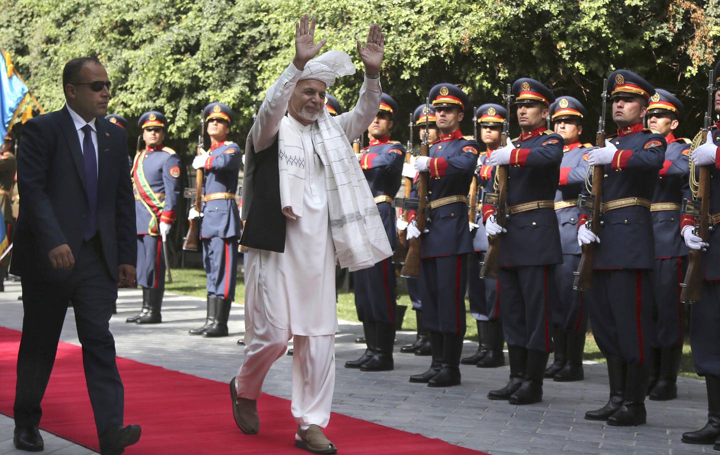 Afghanistan's President Ashraf Ghani, center, greets as he arrives to offer Eid al-Adha prayers at the presidential palace in Kabul, Afghanistan, Sunday, Aug. 11, 2019.