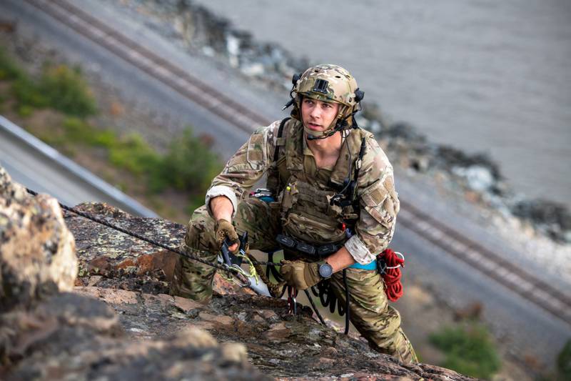 Staff Sgt. Trenten Collins, a tactical air control party specialist assigned to Detachment 1, 3rd Air Support Operations Squadron, approaches the cliff summit during mountaineering training at Sunshine Ridge, Alaska, July 22, 2022. (Senior Airman Patrick Sullivan/Air Force)
