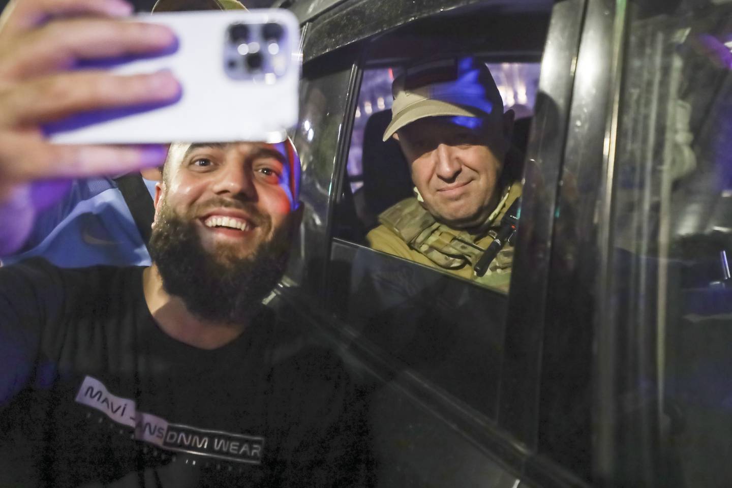 Yevgeny Prigozhin, the owner of the Wagner Group military company, right, sits inside a military vehicle posing for a selfie photo with a local civilian on a street in Rostov-on-Don, Russia, Saturday, June 24, 2023, prior to leaving an area of the headquarters of the Southern Military District.