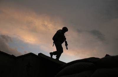 In this Sept. 18, 2009, file, photo, a soldier from the U.S. Army's 118th Military Police Co., based at Fort Bragg, N.C., respond to shots fired at a combat outpost in the Jalrez Valley in Afghanistan's Wardak Province.