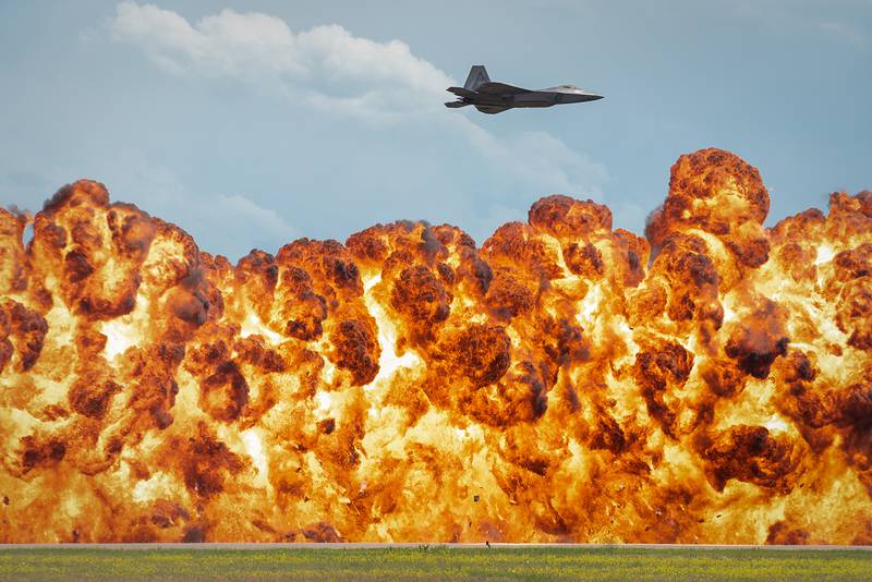 A 1,000-foot wall of fire explodes below the F-22 Raptor during a high-speed pass maneuver at the “Mission Over Malmstrom” open house event in Great Falls, Mont., July 14, 2019.