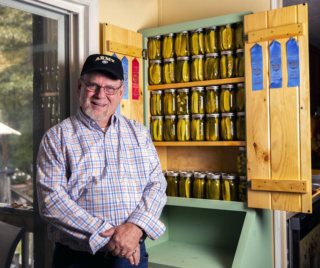Boyd Elliott smiles in front of his pickle cabinet in his home in Louisa County on Thursday, Oct. 13, 2022 in Fredericksburg, Va.