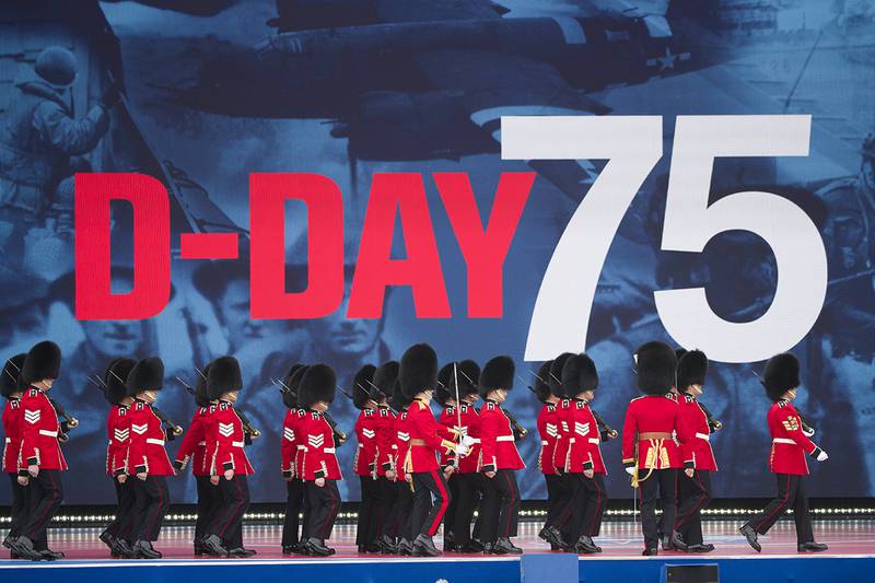 An honor guard marches on stage during a ceremony to mark the 75th Anniversary of D-Day,