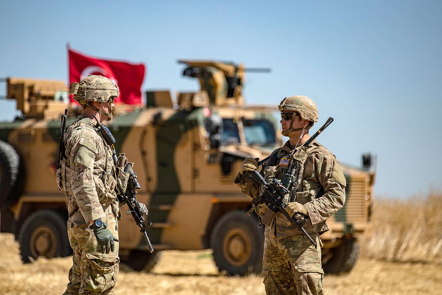 U.S. soldiers chat next to a Turkish military vehicle