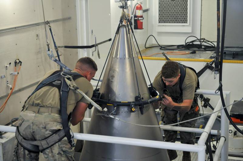 In this image provided by the U.S. Air Force, Senior Airman Jacob Deas, 23, left, and Airman 1st Class Jonathan Marrs, 21, right, secure the titanium shroud at the top of a Minuteman III intercontinental ballistic missile on Aug. 24, 2023, at the Bravo 9 silo at Malmstrom Air Force Base in Montana.