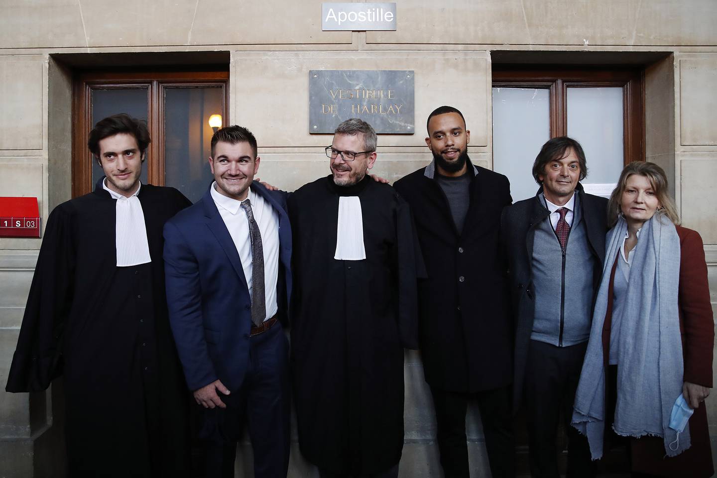 From left, lawyer Louis Cailliez, Alek Skarlatos, lawyer Thibault de Montbrial, Anthony Sadler, Mark Moogalian and Isabelle Risacher Moogalian, pose at the end of their hearing during the Thalys attack trial at the Paris courthouse, Friday, Nov. 20, 2020.