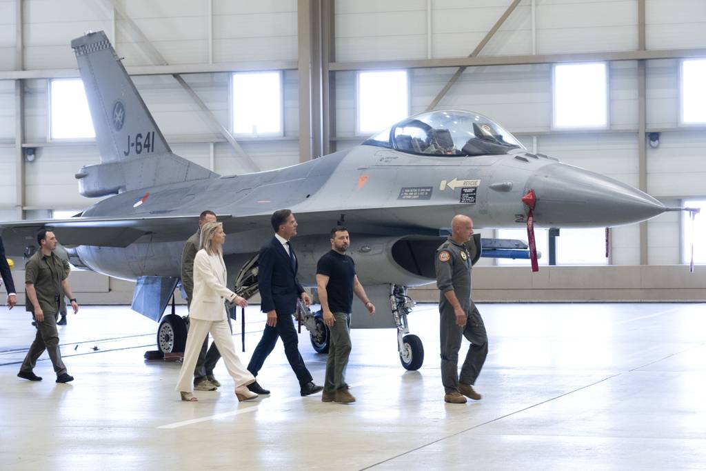 Ukrainian President Volodymyr Zelenskyy, second right, and Dutch caretaker Prime Minister Mark Rutte, center, look at F-16 fighter jets in Eindhoven, Netherlands, Sunday, Aug. 20, 2023.