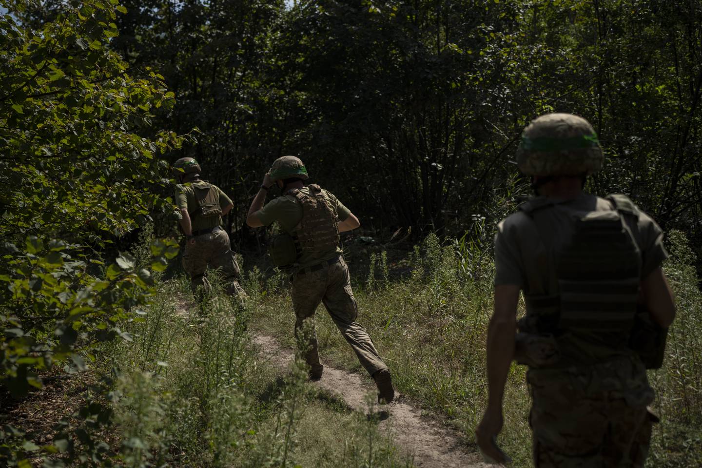 Ukrainian soldiers run towards a mortar position on the frontline in the outskirts of Kreminna, Ukraine, Wednesday, Aug. 16, 2023.