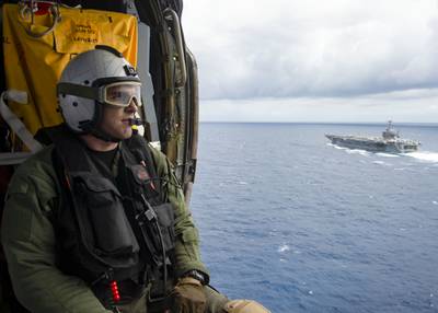 Naval Air Crewman (Helicopter) 3rd Class Jake Shelton observes the Nimitz-class aircraft carrier USS Harry S. Truman (CVN 75) in the Atlantic Ocean on May 27, 2020.