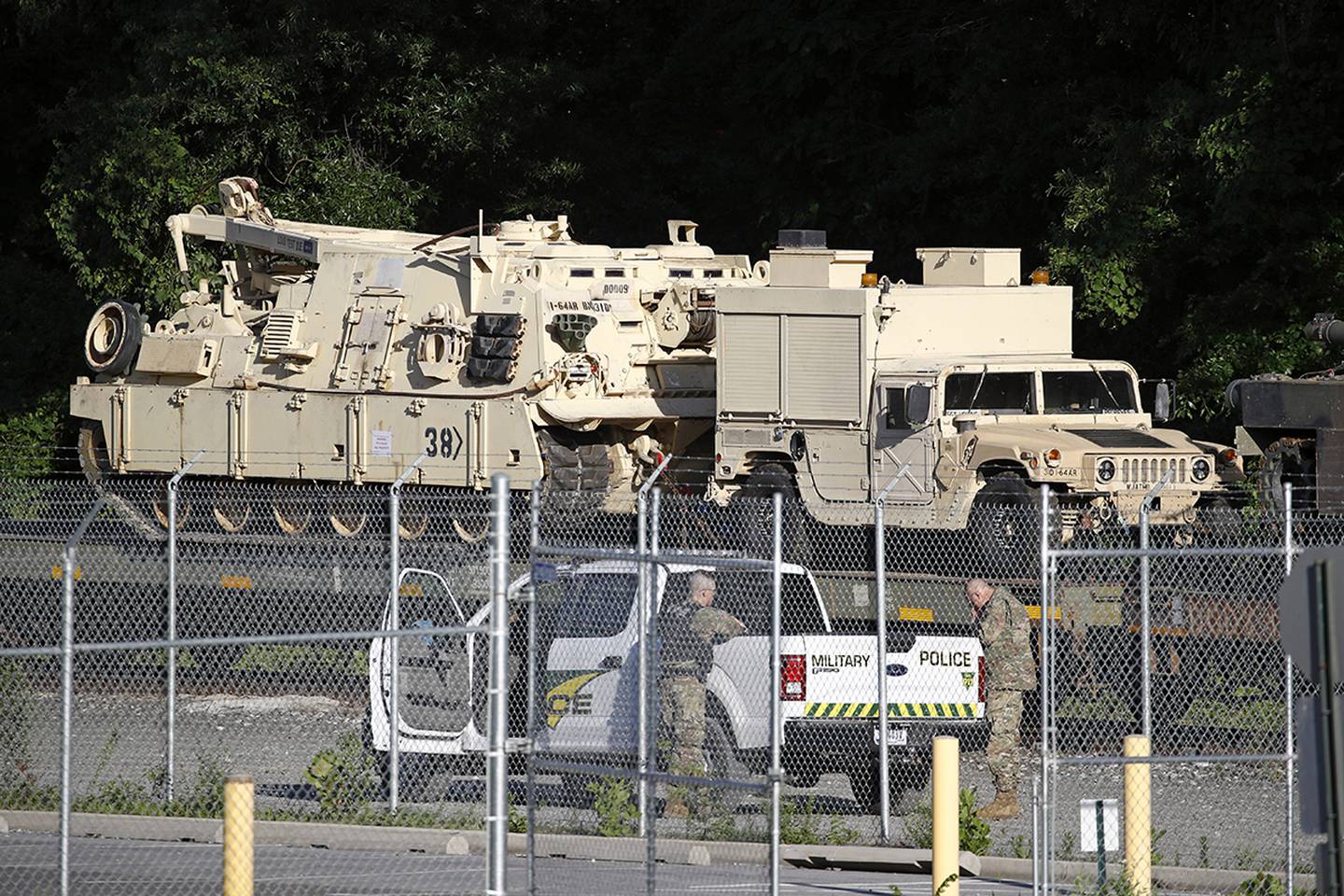 Military police stand military vehicles on a flat car in a rail yard, Monday, July 1, 2019, in Washington, ahead of a Fourth of July celebration that President Donald Trump says will include military hardware.