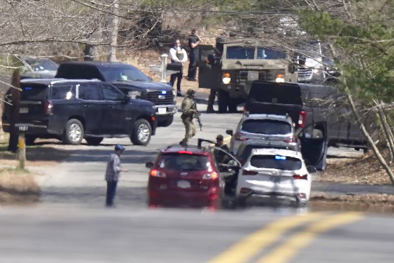 Members of law enforcement assemble on a road, Thursday, April 13, 2023, in Dighton, Mass., near where FBI agents converged on the home of a Massachusetts Air National Guard member who has emerged as a main person of interest in the disclosure of highly classified military documents on the Ukraine.