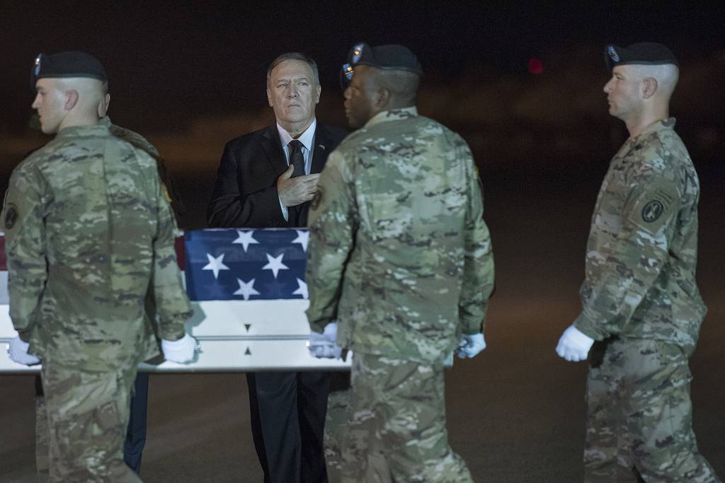 An Army carry team moves a transfer case containing the remains of Sgt. 1st Class Elis Barreto Ortiz, 34, from Morovis, Puerto Rico, past Secretary of State Mike Pompeo, Saturday, Sept. 7, 2019, at Dover Air Force Base, Del.