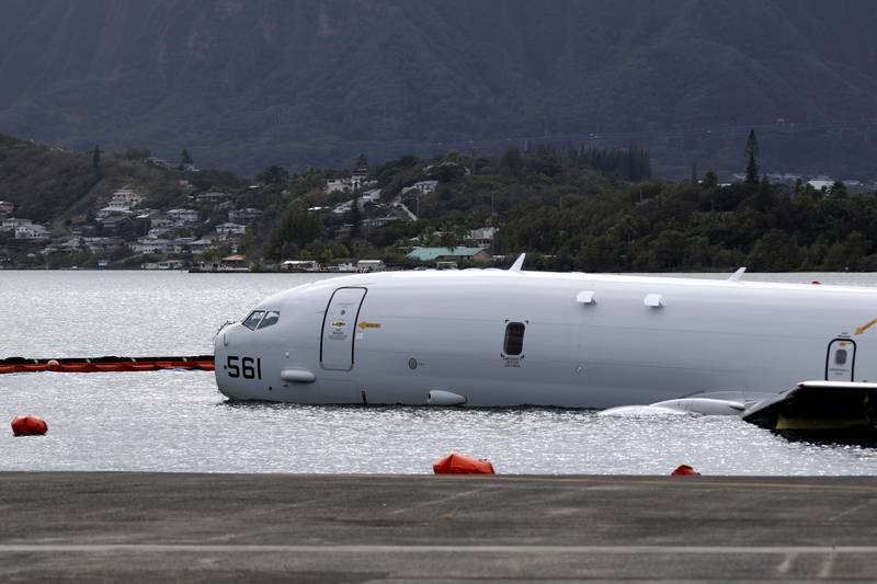 A Navy P-8A plane that overshot a runway at Marine Corps Base Hawaii and landed in shallow water offshore sits on a reef and sand in Kaneohe Bay, Hawaii, on Monday, Nov. 27, 2023.