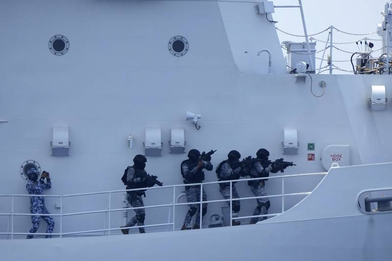 A Philippine Coast Guard personnel, left, participate in a drill on board the PCG Melchora Aquino ship off the waters of Bataan, Philippines, Tuesday, June 6, 2023.