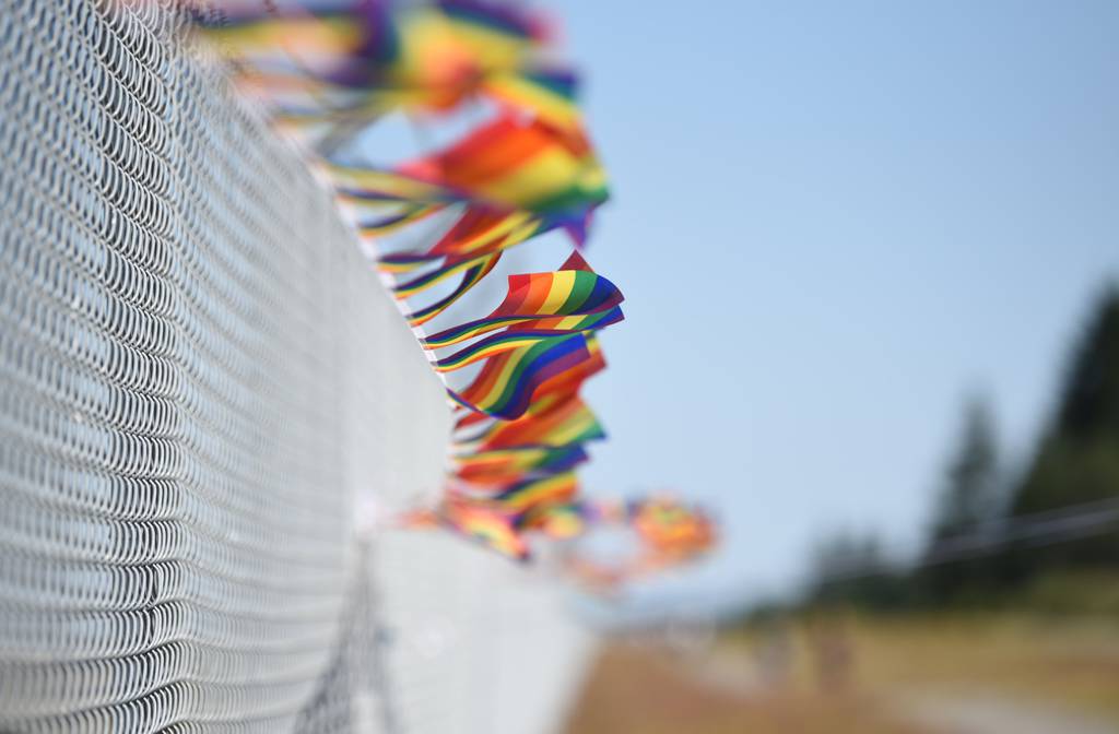 A fence is decorated with pride flags during a pride month event at Joint Base Lewis-McChord, Washington, June 28, 2023.