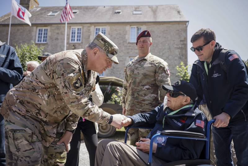 U.S. Gen. Mark Milley, left, shakes hands with Tec4 Moshe D. Lenske during a gathering in preparation of the 79th D-Day anniversary in La Fiere, Normandy, France, Sunday, June 4, 2023.