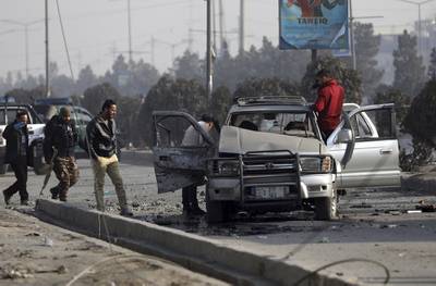 Security personnel inspect the site of a bomb attack in Kabul, Afghanistan, Tuesday, Feb. 2, 2021.