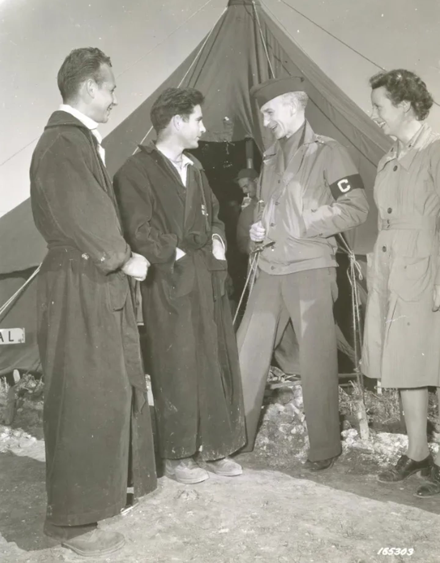 Ernie Pyle, of Scripps-Howard Newspapers, interviews Sgt. Ralph Gower of Sacramento, California; Pvt. Raymond Astrackon (left) of New York City; and 2nd. Lt. Annette Heaton of Detroit, Michigan, attached to an evacuation hospital on Dec. 2, 1942, in North Africa.