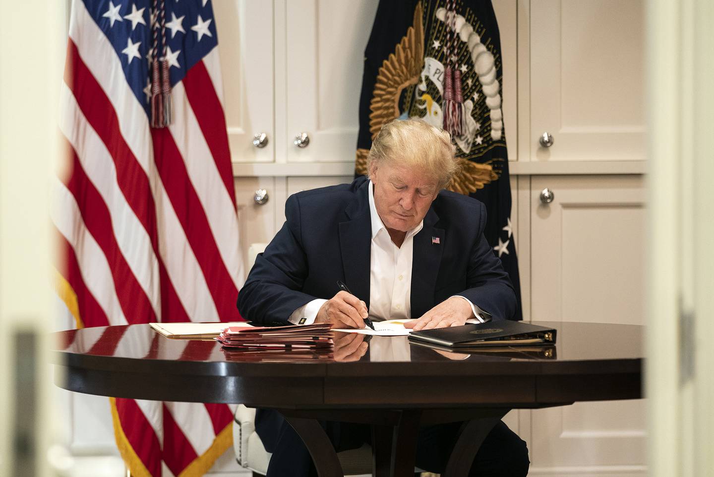 President Donald Trump works in the Presidential Suite at Walter Reed National Military Medical Center in Bethesda, Md., Saturday, Oct. 3, 2020, after testing positive for COVID-19.