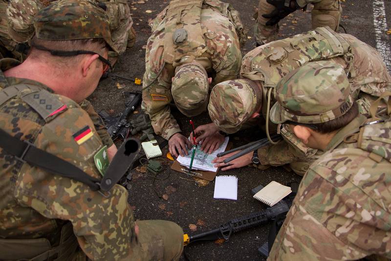 A team of soldiers from 2d Cavalry Regiment and a Panzer Brigade from the German Army plot a point on a map for a land navigation event during a cavalry spur ride Nov. 2, 2017, in the Grafenwoehr Training Area, Germany.
