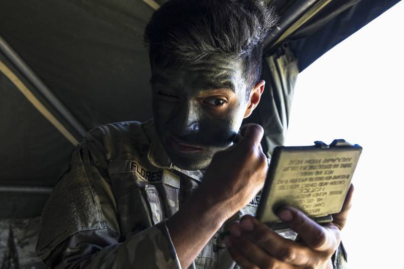 Army Spc. Christian Flores applies face paint prior to mission during the U.S. Army Europe European Best Warrior Competition at U.S. Army Garrison Hohenfels Training Area, Germany, July 29, 2020.