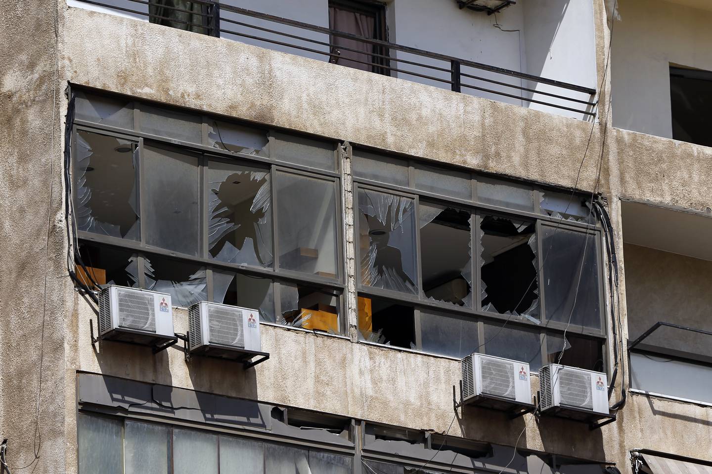 Broken windows are seen on the 11-floor building that houses the media office in a stronghold of the Lebanese Hezbollah group in a southern suburb of Beirut, Lebanon, Sunday, Aug. 25, 2019.