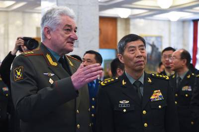 In this handout photo released by Russian Defense Ministry Press Service, Chief of the Military Academy of the General Staff of the Armed Forces of the Russian Federation Col. Gen. Vladimir Zarudnitsky, left, escorts China's Defense Minister Gen. Li Shangfu during a visit to Military Academy of the General Staff of the Armed Forces of the Russian Federation in Moscow, Russia, Monday, April 17, 2023.